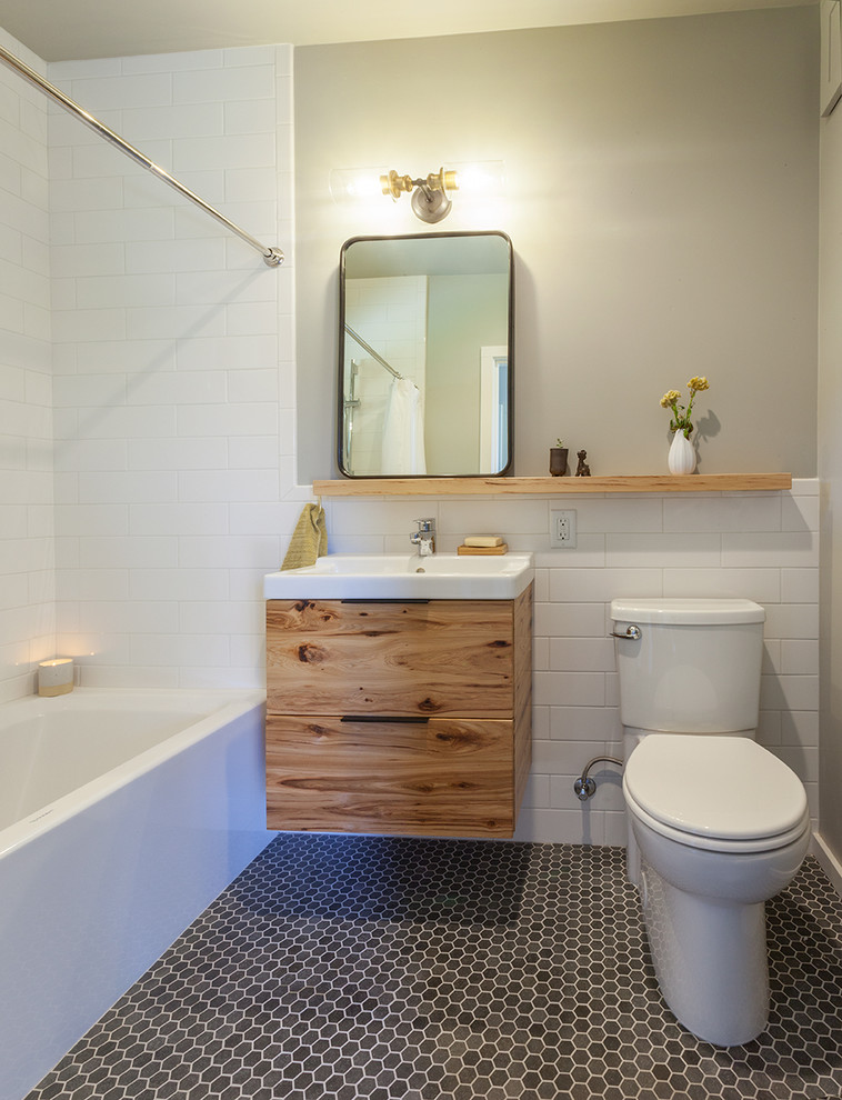 Пример оригинального дизайна: ванная комната в стиле неоклассика (современная классика) с плоскими фасадами, фасадами цвета дерева среднего тона, ванной в нише, душем над ванной, раздельным унитазом, плиткой кабанчик, белыми стенами, душевой кабиной, консольной раковиной, серым полом, шторкой для ванной и зеркалом с подсветкой