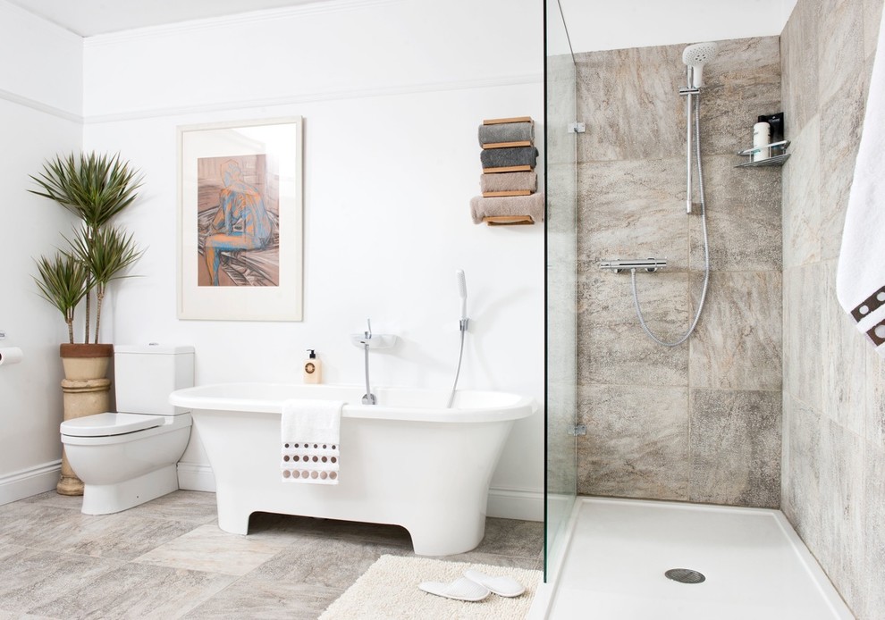 Photo of a large modern ensuite bathroom in Dorset with a freestanding bath, a walk-in shower, a one-piece toilet, porcelain flooring and white walls.