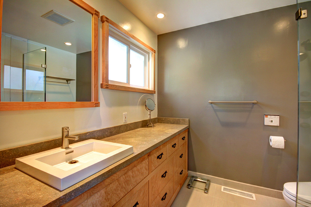 Inspiration for a mid-sized 3/4 corner shower remodel in San Francisco with a vessel sink, flat-panel cabinets, medium tone wood cabinets, solid surface countertops and gray walls