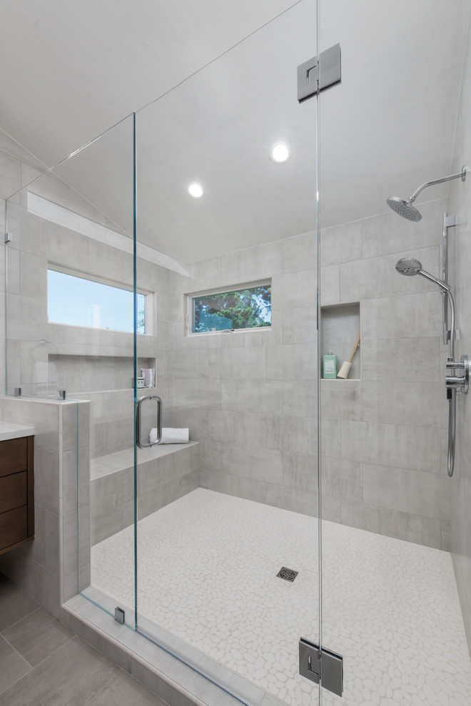 This is an example of an expansive modern ensuite bathroom in San Francisco with flat-panel cabinets, brown cabinets, an alcove shower, a one-piece toilet, grey tiles, ceramic tiles, grey walls, ceramic flooring, a submerged sink, engineered stone worktops, grey floors, a hinged door and white worktops.