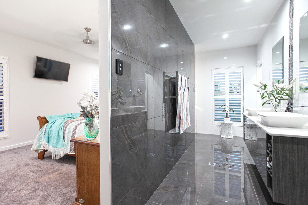 Photo of a medium sized contemporary ensuite bathroom in Other with a walk-in shower, a wall mounted toilet, grey tiles, cement tiles, engineered stone worktops, flat-panel cabinets, grey cabinets, ceramic flooring, grey floors, white worktops, double sinks and a floating vanity unit.