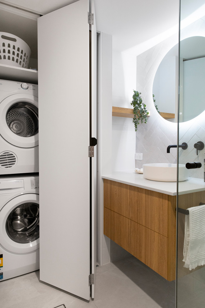 Medium sized contemporary shower room bathroom in Brisbane with flat-panel cabinets, medium wood cabinets, grey tiles, white walls, porcelain flooring, a vessel sink, grey floors, white worktops, a laundry area and a floating vanity unit.