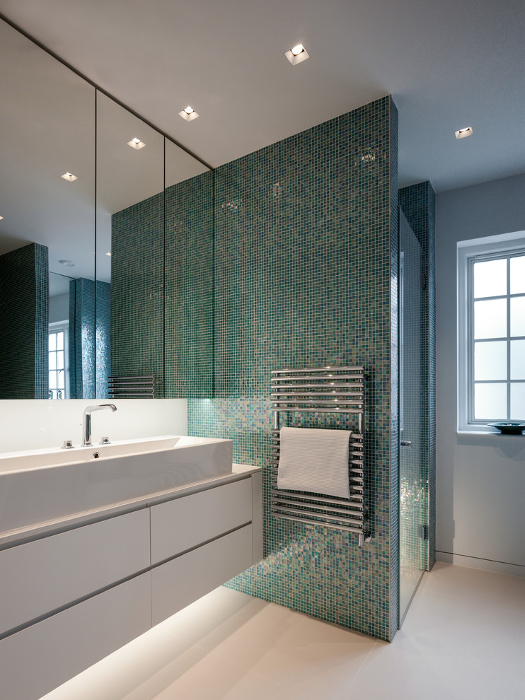 Contemporary bathroom in Kent with flat-panel cabinets, white cabinets, an alcove shower, blue tiles, green tiles, mosaic tiles, white walls, a vessel sink and a hinged door.