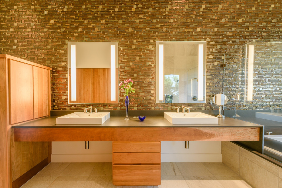 Пример оригинального дизайна: главная ванная комната в современном стиле с плоскими фасадами, светлыми деревянными фасадами, плиткой мозаикой, полом из сланца, настольной раковиной, столешницей из искусственного камня, разноцветной плиткой и зеркалом с подсветкой