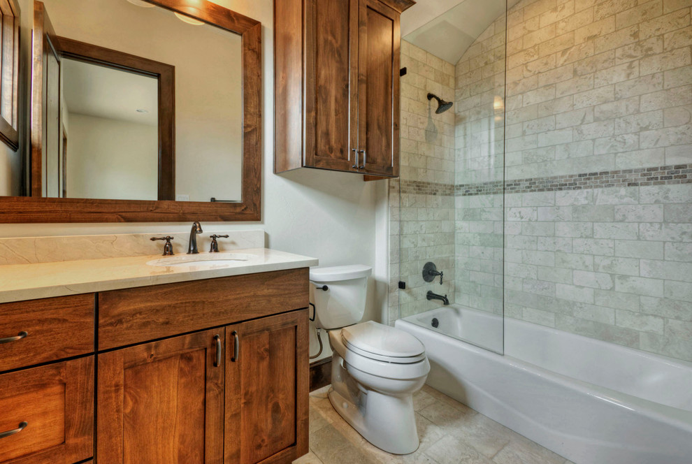 Aménagement d'une grande salle de bain campagne en bois brun avec un lavabo encastré, un placard avec porte à panneau encastré, un plan de toilette en granite, une baignoire posée, un combiné douche/baignoire, WC séparés, un carrelage beige, des carreaux de céramique, un mur beige et un sol en carrelage de céramique.