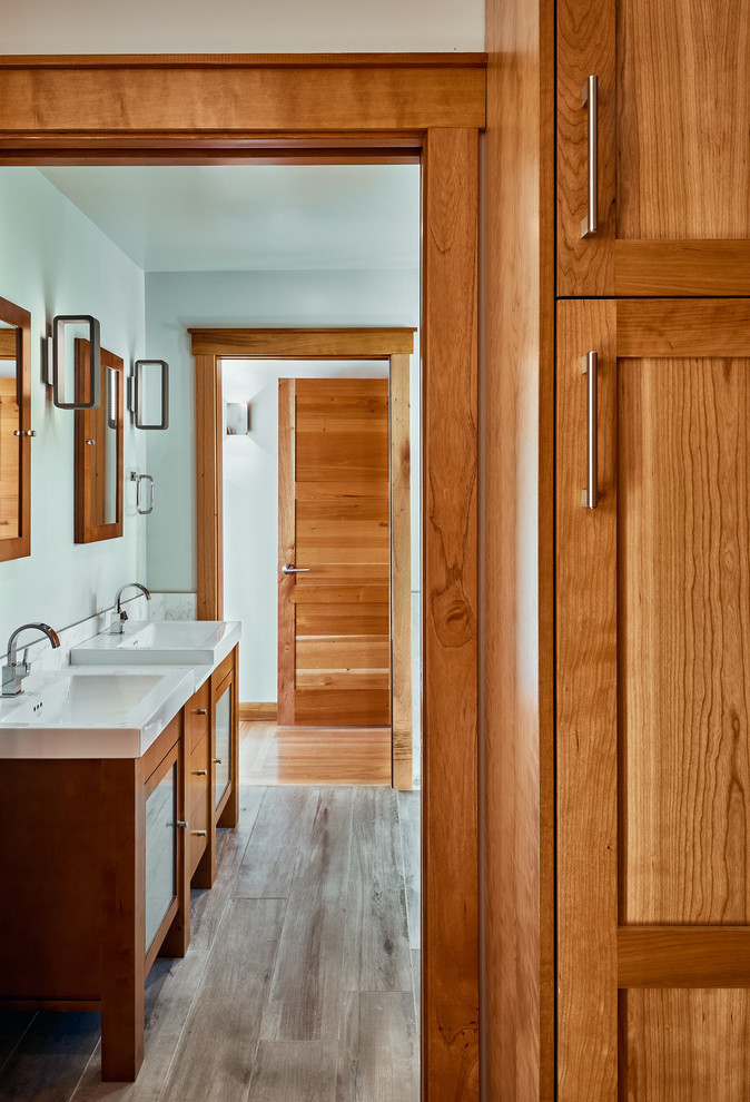 Imagen de cuarto de baño principal tradicional renovado de tamaño medio con armarios tipo mueble, puertas de armario de madera oscura, baldosas y/o azulejos grises, suelo de baldosas de porcelana, lavabo integrado, encimera de cuarcita y suelo gris