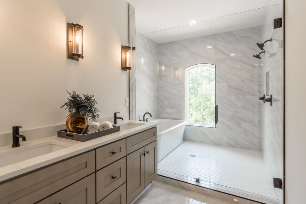 Inspiration for a large transitional master white tile and marble tile mosaic tile floor, white floor, double-sink and brick wall bathroom remodel in Atlanta with shaker cabinets, brown cabinets, a one-piece toilet, white walls, a drop-in sink, quartz countertops, a hinged shower door, white countertops and a built-in vanity