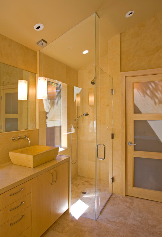 Пример оригинального дизайна: главная ванная комната среднего размера в современном стиле с плоскими фасадами, бежевыми фасадами, накладной ванной, душем без бортиков, унитазом-моноблоком, бежевой плиткой, плиткой из известняка, желтыми стенами, полом из известняка, настольной раковиной, столешницей из известняка, желтым полом, душем с распашными дверями и бежевой столешницей