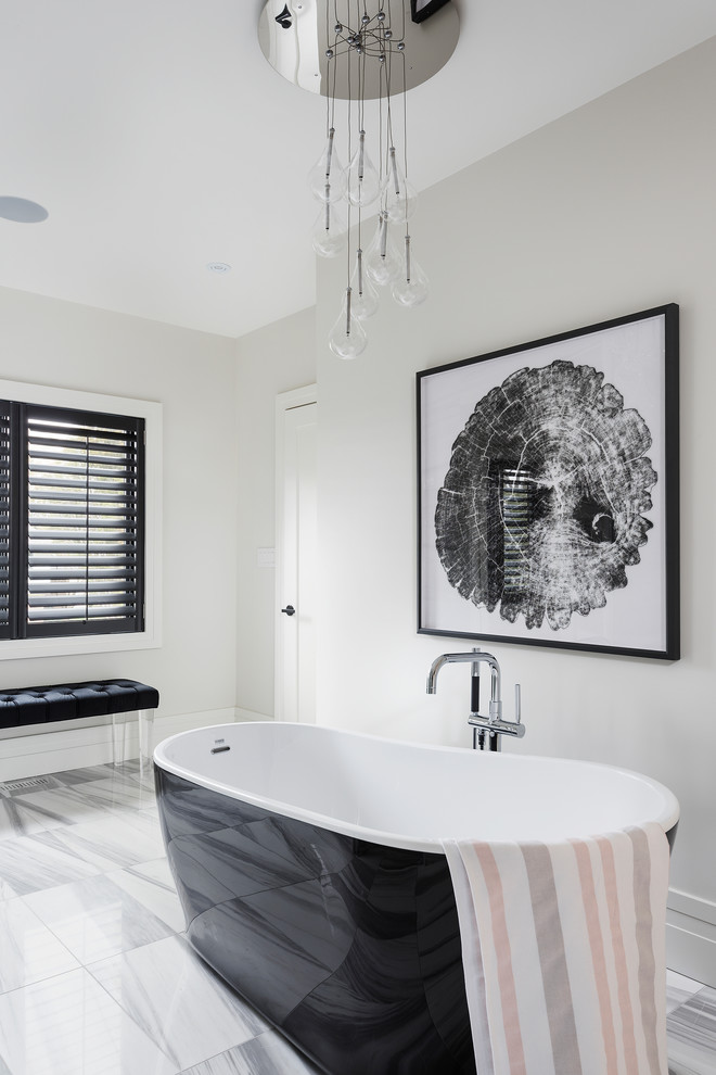 Immagine di una stanza da bagno chic con vasca freestanding, pareti bianche e pavimento bianco