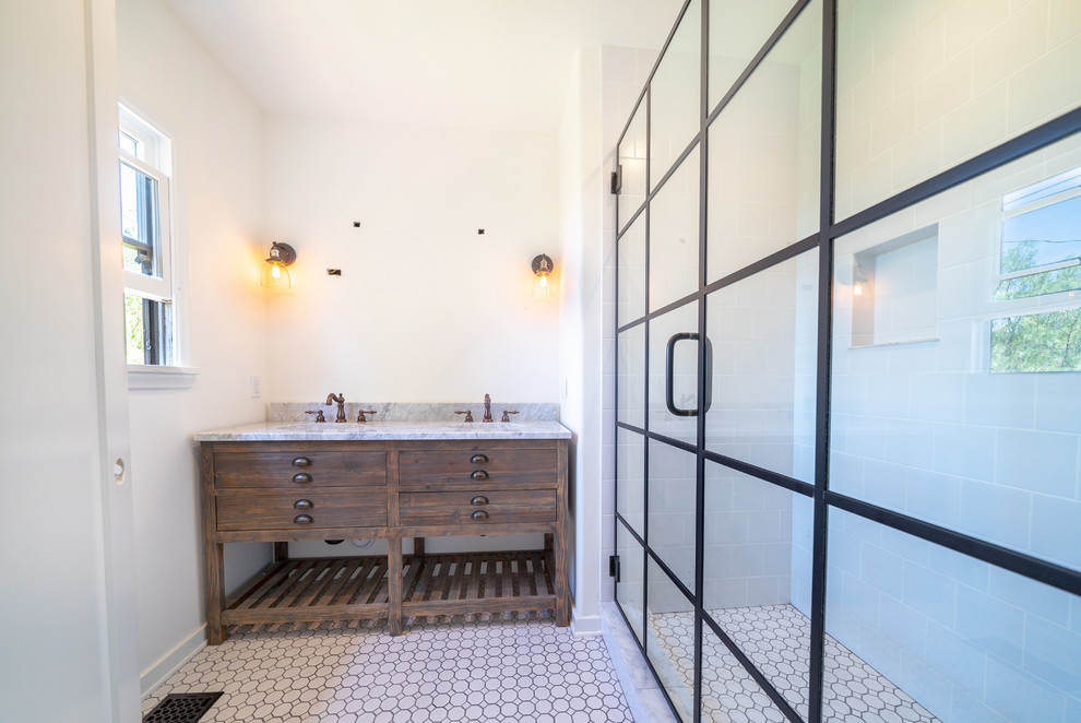 Inspiration for a medium sized mediterranean ensuite bathroom in Los Angeles with beaded cabinets, dark wood cabinets, a claw-foot bath, an alcove shower, a one-piece toilet, white tiles, metro tiles, white walls, mosaic tile flooring, a submerged sink, marble worktops, white floors, a hinged door and grey worktops.