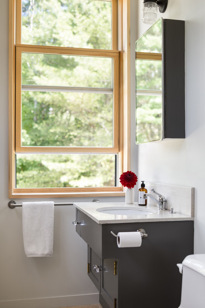 Foto de cuarto de baño clásico renovado con lavabo bajoencimera, armarios estilo shaker, puertas de armario negras y paredes blancas