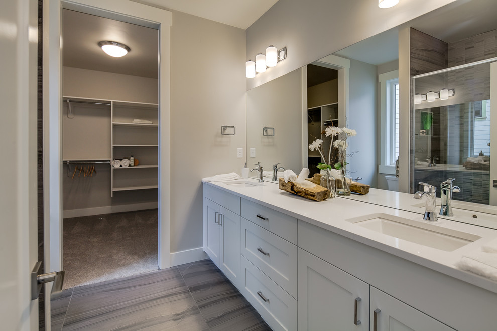 Inspiration for a large transitional master beige tile and ceramic tile laminate floor and beige floor bathroom remodel in Other with beige walls, shaker cabinets, white cabinets, a two-piece toilet, an undermount sink, solid surface countertops and white countertops