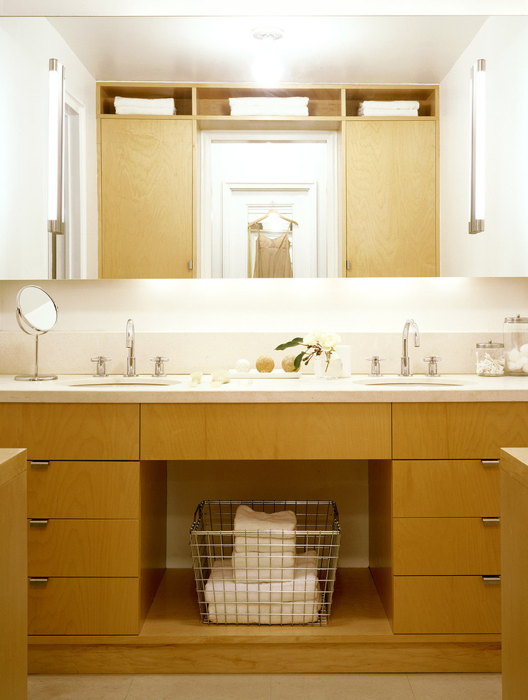 Réalisation d'une salle de bain design en bois clair avec un placard à porte plane.