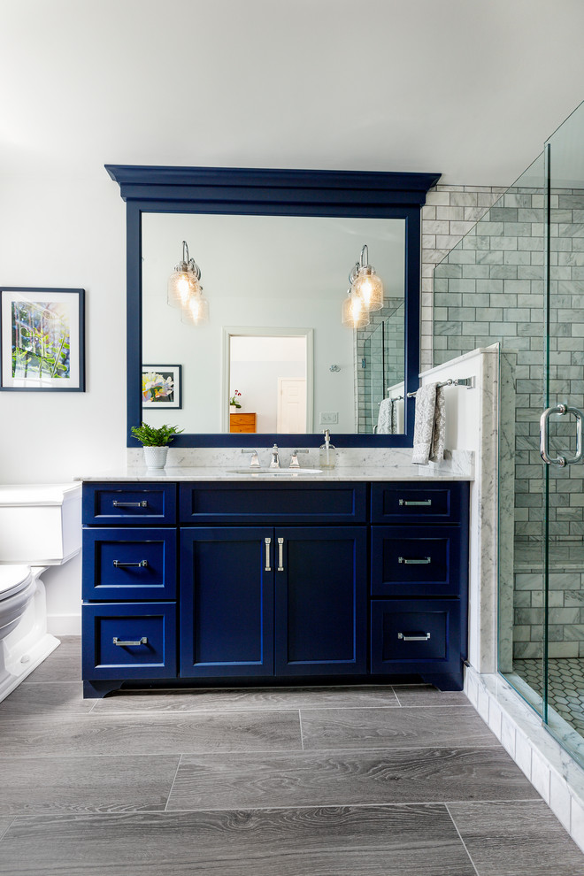 Идея дизайна: главная ванная комната среднего размера в стиле неоклассика (современная классика) с фасадами с утопленной филенкой, синими фасадами, открытым душем, унитазом-моноблоком, серой плиткой, керамической плиткой, серыми стенами, полом из керамической плитки, накладной раковиной, мраморной столешницей, серым полом, душем с распашными дверями и белой столешницей