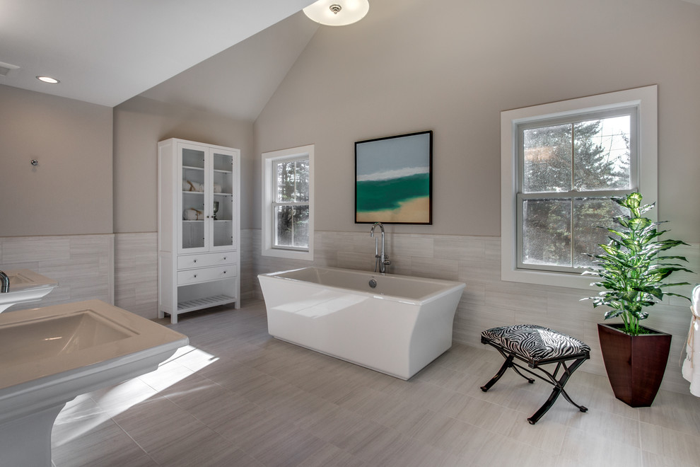 Foto di una stanza da bagno padronale design di medie dimensioni con vasca freestanding, pareti beige, pavimento in gres porcellanato, lavabo a colonna e pavimento beige