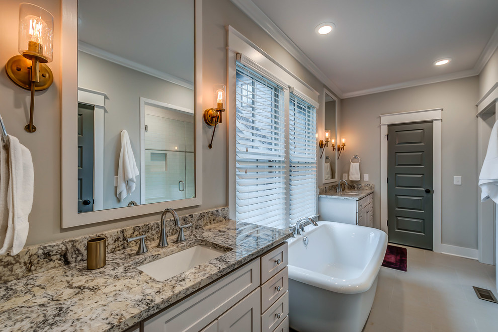 ナッシュビルにあるトランジショナルスタイルのおしゃれな浴室 (置き型浴槽、グレーの壁、アンダーカウンター洗面器) の写真