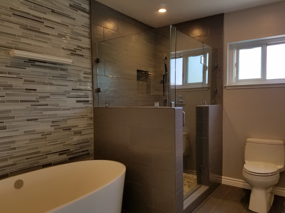 Inspiration for a traditional bathroom in Los Angeles with shaker cabinets, white cabinets, a freestanding bath, a corner shower, grey tiles, glass sheet walls, engineered stone worktops and a hinged door.