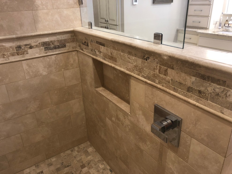 Klassisk inredning av ett stort en-suite badrum, med våtrum, beige kakel, travertinkakel, travertin golv, beiget golv, med dusch som är öppen, luckor med upphöjd panel, vita skåp, en toalettstol med hel cisternkåpa, grå väggar, ett undermonterad handfat och granitbänkskiva