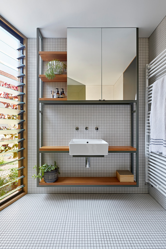 Inspiration for a scandinavian shower room bathroom in Melbourne with open cabinets, white tiles, a wall-mounted sink, wooden worktops, white floors and brown worktops.