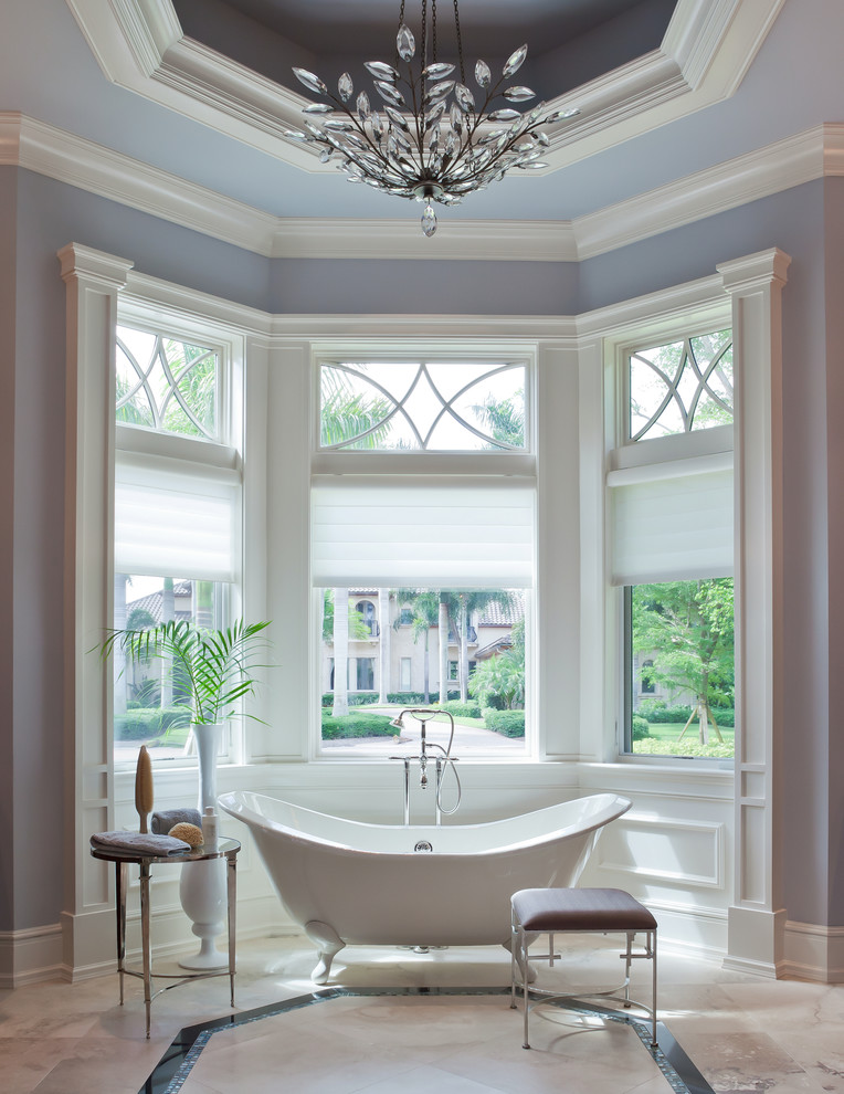 Inredning av ett klassiskt stort en-suite badrum, med ett fristående badkar, blå väggar och marmorgolv