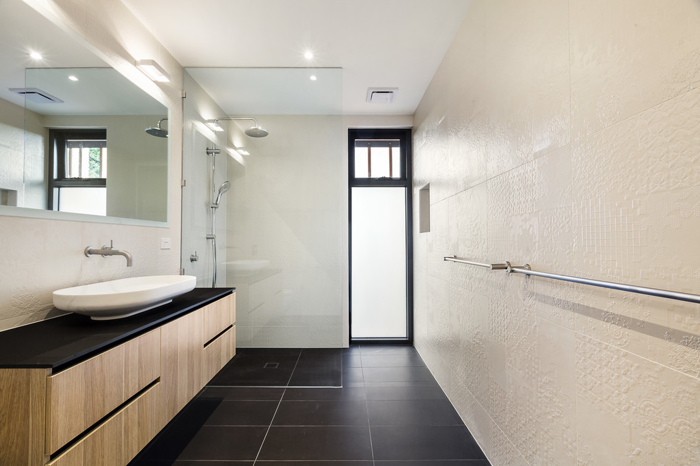 Cette photo montre une grande salle de bain principale moderne avec une douche ouverte, un carrelage beige, des carreaux de céramique, un mur beige, un sol en carrelage de céramique, une vasque, un plan de toilette en stratifié, un sol noir et aucune cabine.