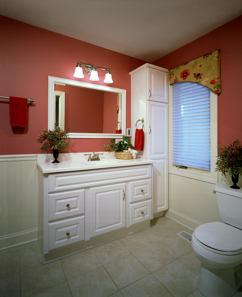 This is an example of a medium sized traditional shower room bathroom in Chicago with raised-panel cabinets, white cabinets, a one-piece toilet, pink walls, ceramic flooring, marble worktops, beige floors, a shower curtain, a submerged sink, an alcove shower, pink tiles, white worktops, a single sink, a freestanding vanity unit, ceramic tiles, a wallpapered ceiling and wallpapered walls.