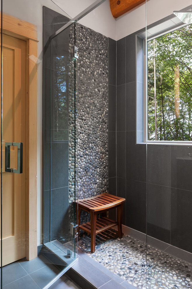 Ejemplo de cuarto de baño tradicional renovado con baldosas y/o azulejos negros, baldosas y/o azulejos multicolor, suelo de baldosas tipo guijarro, ducha con puerta con bisagras y ventanas