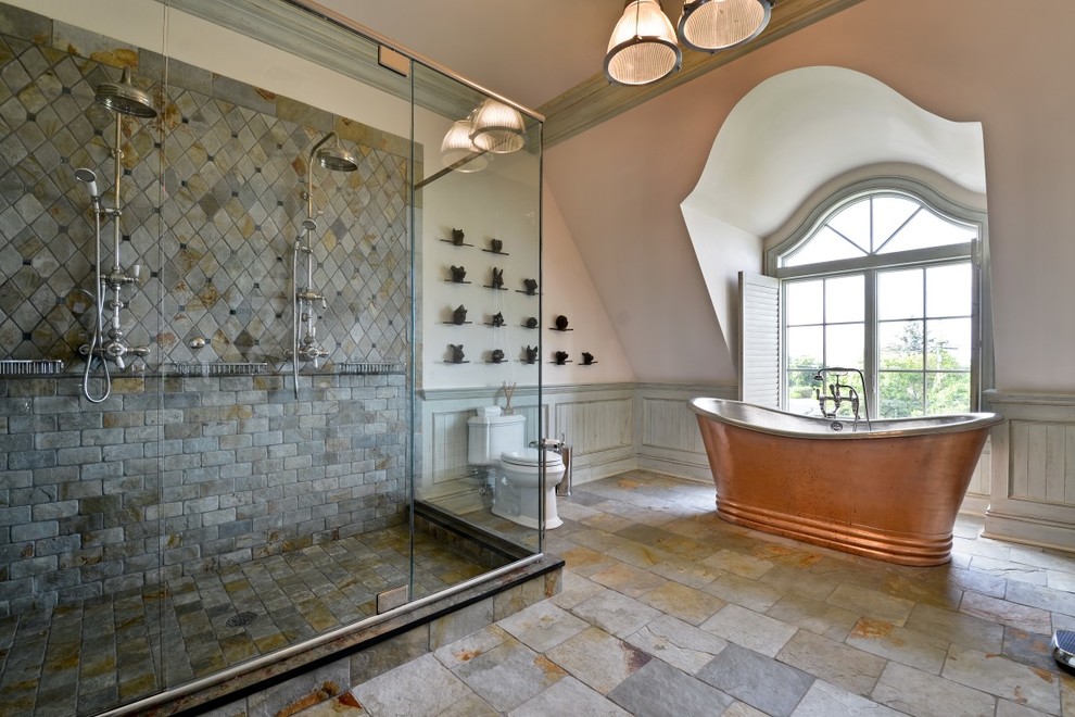 Ispirazione per una grande stanza da bagno padronale design con vasca freestanding, WC a due pezzi, piastrelle grigie, piastrelle in pietra, pareti grigie e pavimento in ardesia