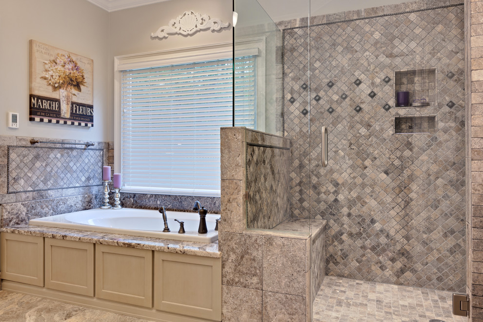 This is an example of a large classic ensuite bathroom in Atlanta with recessed-panel cabinets, beige cabinets, a built-in bath, a double shower, multi-coloured tiles, travertine tiles, porcelain flooring, a hinged door, beige walls, granite worktops, beige floors and beige worktops.