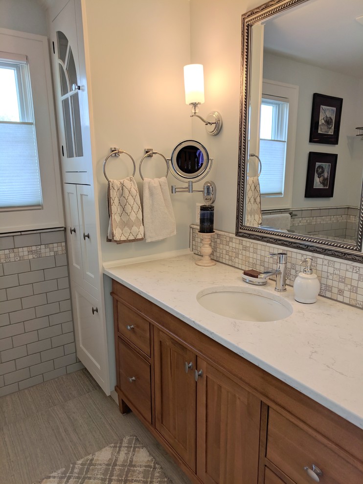 Foto de cuarto de baño principal tradicional renovado pequeño con armarios estilo shaker, puertas de armario de madera oscura, lavabo bajoencimera, encimera de cuarzo compacto y suelo gris