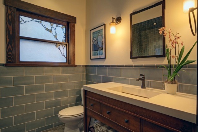 This is an example of a medium sized traditional ensuite bathroom in San Francisco with a trough sink, freestanding cabinets, medium wood cabinets, concrete worktops, a built-in shower, a one-piece toilet, blue tiles, ceramic tiles, white walls and marble flooring.