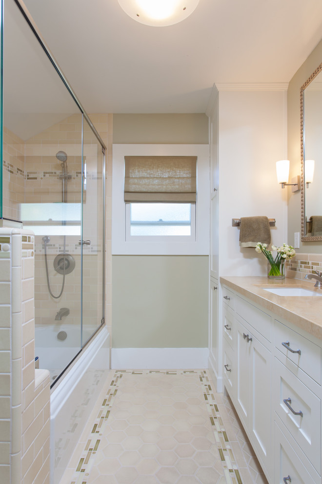 This is an example of a medium sized traditional ensuite bathroom in San Francisco with a submerged sink, shaker cabinets, white cabinets, limestone worktops, a built-in bath, a shower/bath combination, a one-piece toilet, green tiles, porcelain tiles, beige walls and porcelain flooring.