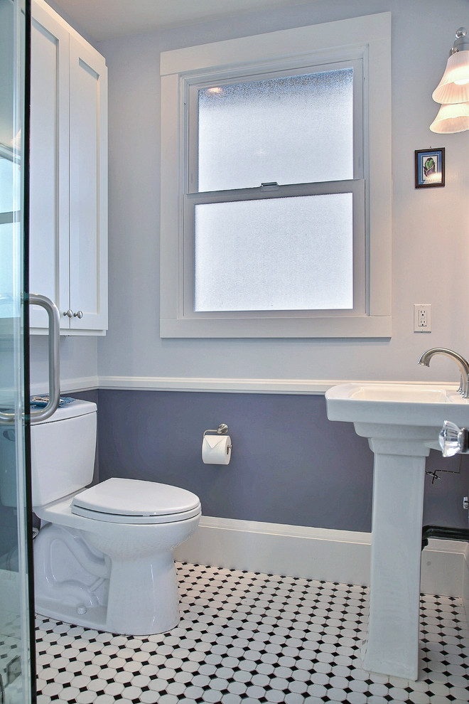 Inspiration for a medium sized traditional family bathroom in San Francisco with recessed-panel cabinets, white cabinets, grey walls, a corner shower, a two-piece toilet, white tiles, lino flooring and a pedestal sink.