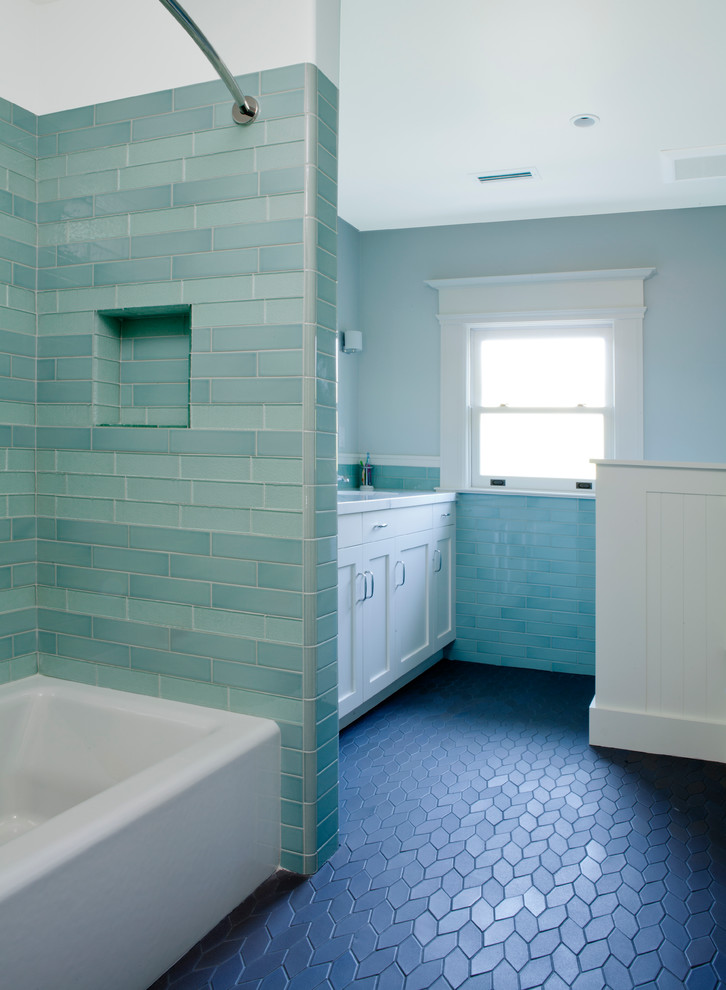 This is an example of a medium sized traditional bathroom in San Francisco with a submerged sink, recessed-panel cabinets, white cabinets, solid surface worktops, an alcove bath, green tiles, ceramic tiles, blue walls and ceramic flooring.