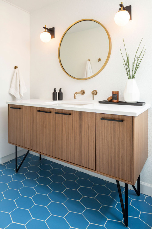 Modern bathroom with walnut wood cabinet and blue hexagon floor tiles, showcasing one of the best kitchen cabinet colors in Canada for a warm, cozy look.