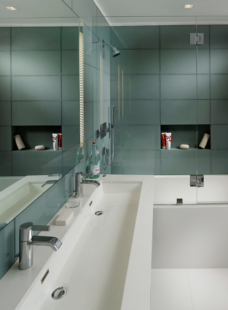 Idées déco pour une salle de bain principale moderne de taille moyenne avec un placard à porte plane, des portes de placard blanches, un combiné douche/baignoire, un carrelage en pâte de verre, une baignoire en alcôve, un carrelage gris, un carrelage vert, une grande vasque, un mur vert, un sol en carrelage de porcelaine et un plan de toilette en surface solide.