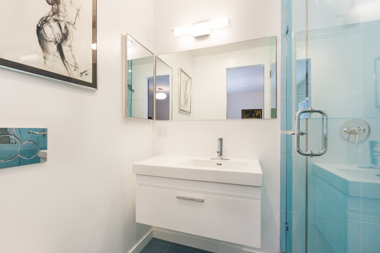 Cette image montre une petite salle de bain design avec un placard à porte plane, des portes de placard blanches, WC séparés, un carrelage bleu, des carreaux de céramique, un mur blanc, un sol en carrelage de céramique, un lavabo posé et un plan de toilette en surface solide.