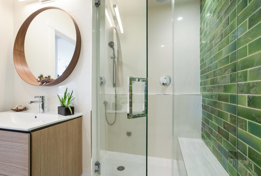 Cette image montre une salle de bain design avec un carrelage vert, un mur vert et une cabine de douche à porte battante.
