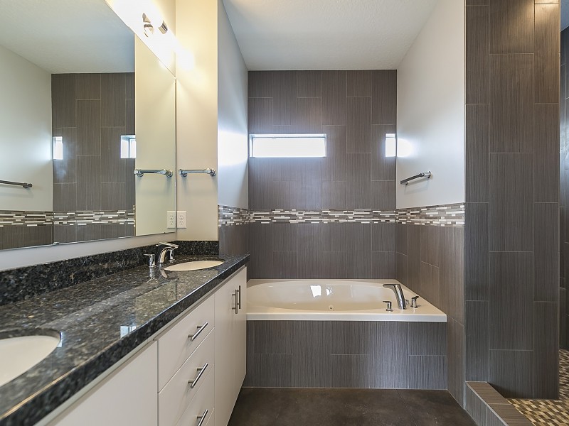Ispirazione per una stanza da bagno padronale minimalista di medie dimensioni con ante lisce, top in granito, piastrelle marroni e piastrelle in ceramica