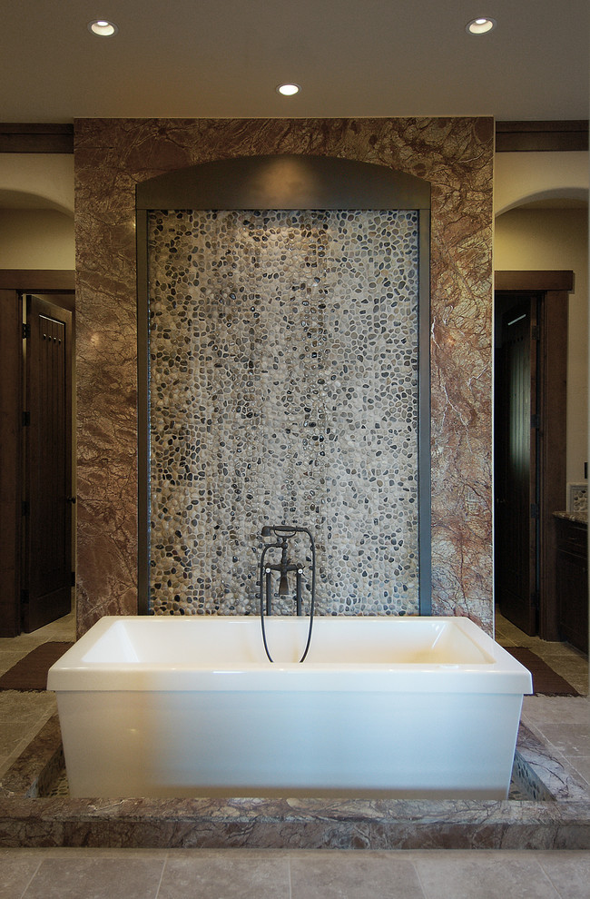 На фото: огромная главная ванная комната в стиле рустика с отдельно стоящей ванной, двойным душем, коричневой плиткой, галечной плиткой и бежевыми стенами