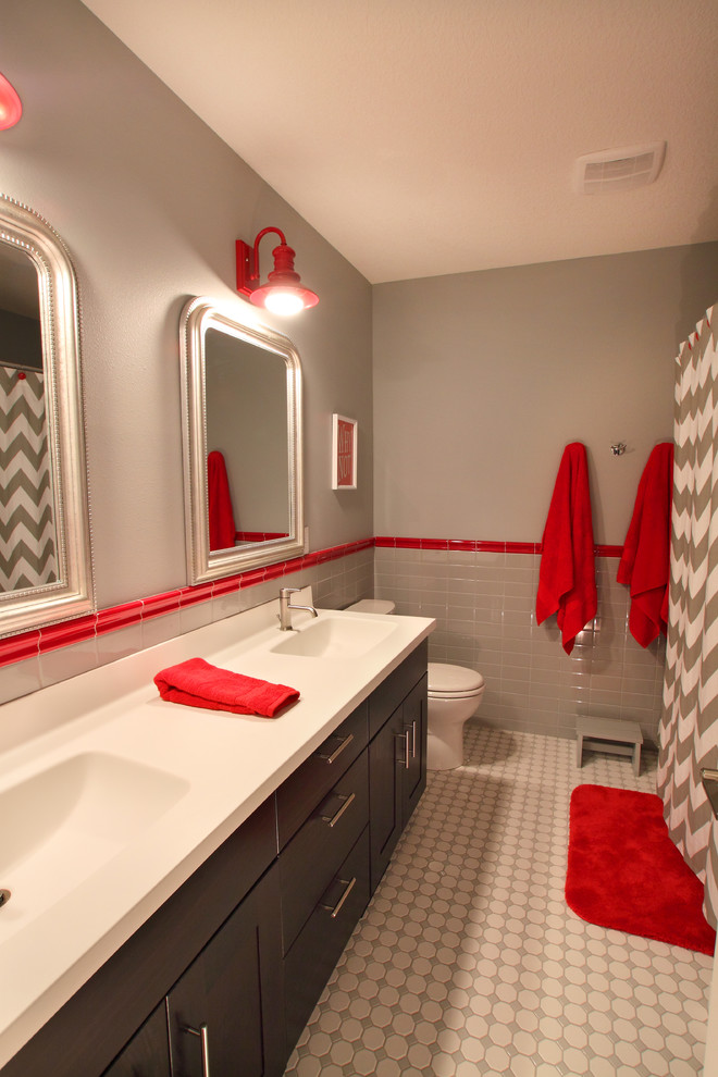 Exemple d'une salle de bain moderne en bois foncé de taille moyenne pour enfant avec un placard à porte plane, un carrelage gris, des carreaux de céramique, un mur gris, un sol en carrelage de céramique et un lavabo intégré.