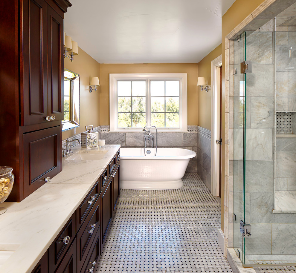 Exempel på ett klassiskt en-suite badrum, med skåp i shakerstil, skåp i mörkt trä, marmorbänkskiva, ett fristående badkar, en dusch i en alkov, grå kakel, gula väggar och klinkergolv i porslin