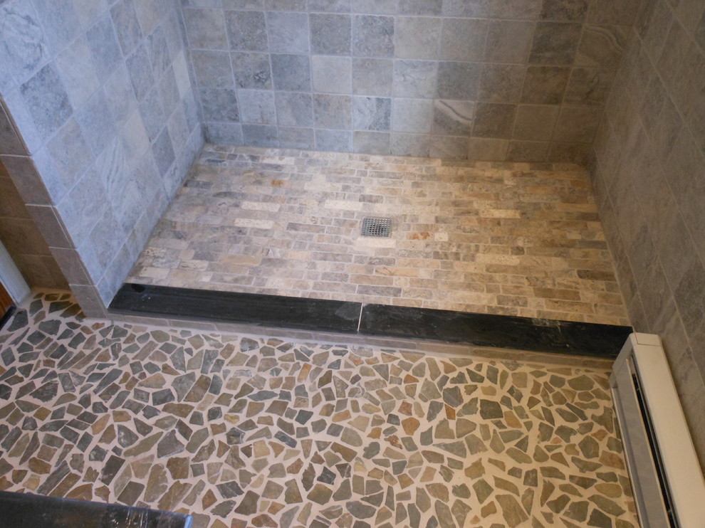 Immagine di una piccola stanza da bagno minimal con vasca da incasso, doccia aperta, WC monopezzo, piastrelle di vetro, pareti beige e pavimento con piastrelle di ciottoli