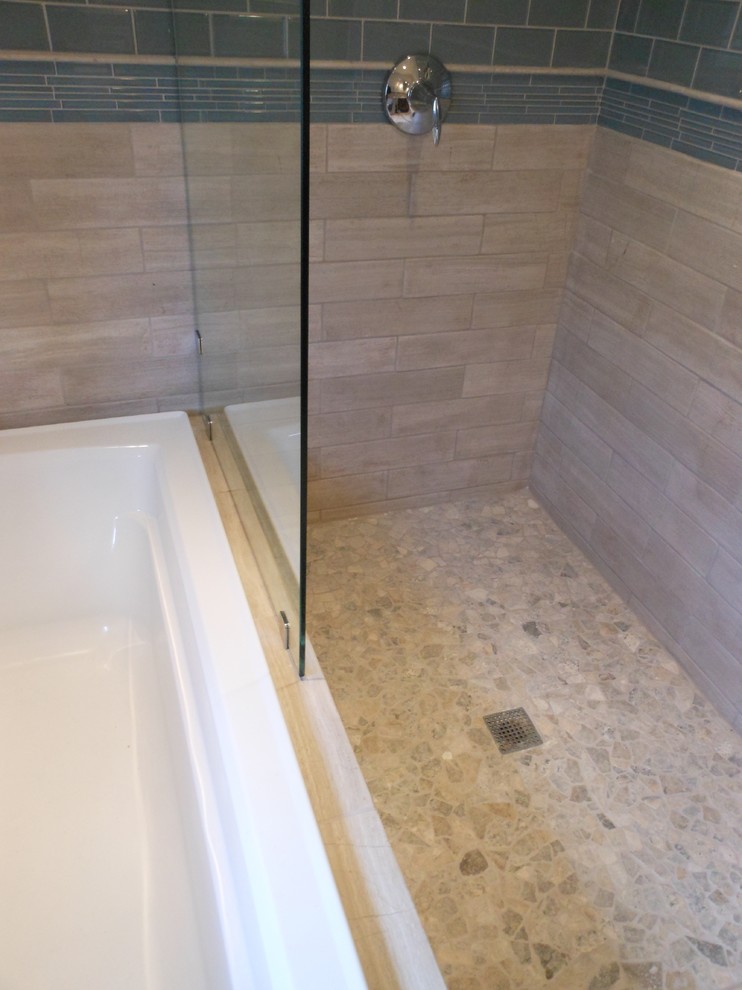 Photo of a small contemporary half tiled bathroom in Philadelphia with a built-in bath, a walk-in shower, glass tiles, pebble tile flooring, a one-piece toilet and beige walls.