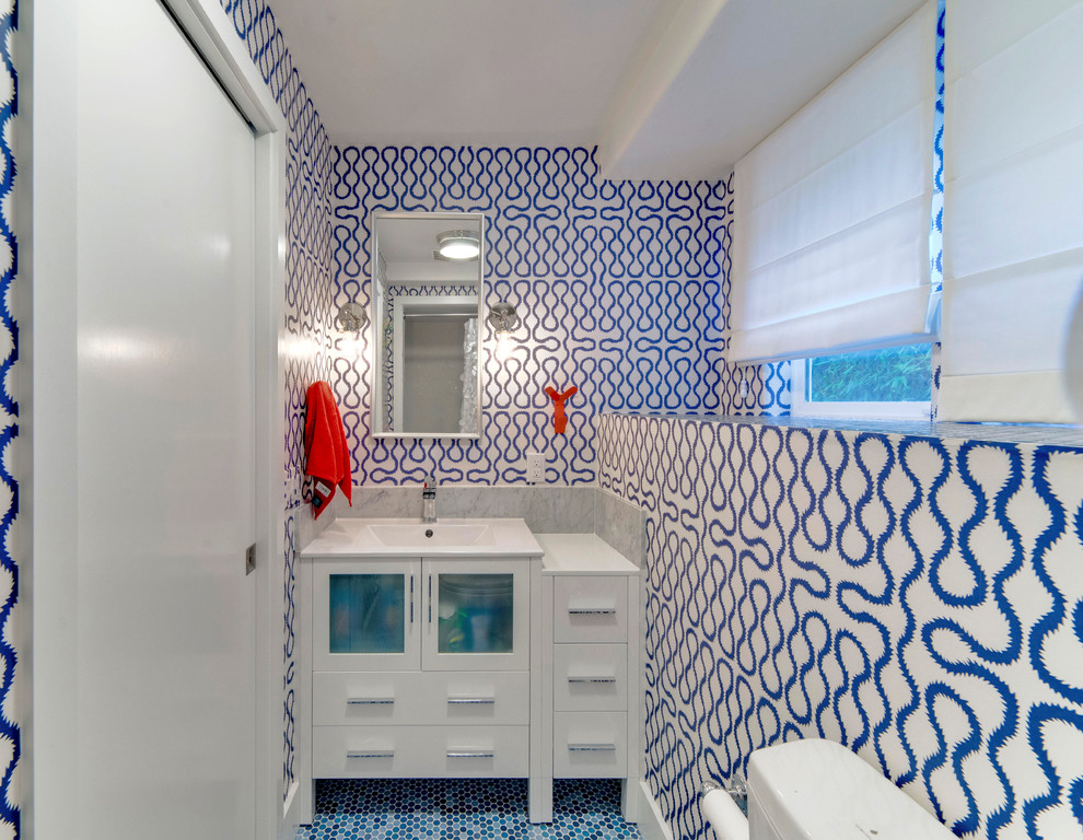 Foto på ett litet vintage badrum för barn, med ett integrerad handfat, luckor med glaspanel, vita skåp, bänkskiva i akrylsten, en dusch i en alkov, en toalettstol med hel cisternkåpa, blå kakel, porslinskakel, blå väggar och klinkergolv i keramik