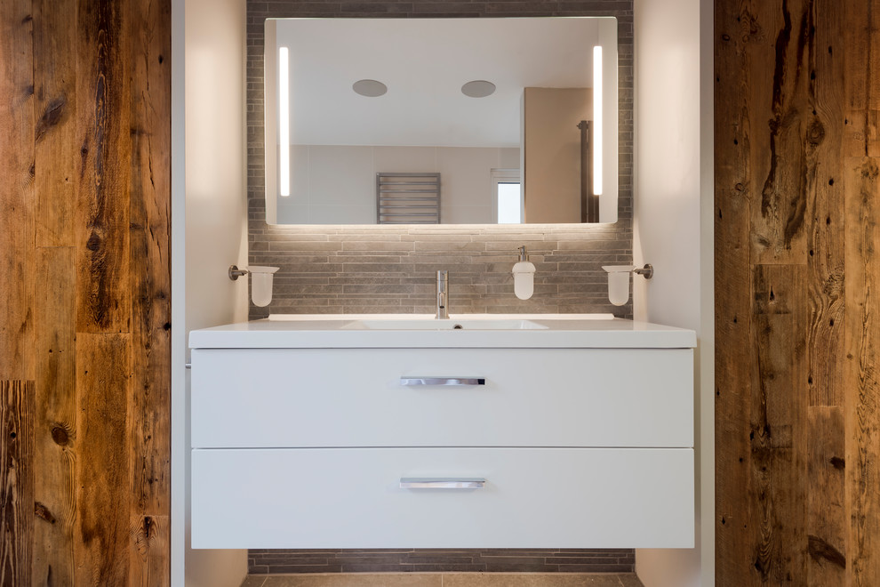 Exempel på ett mellanstort modernt en-suite badrum, med släta luckor, skåp i mellenmörkt trä, ett fristående badkar, en öppen dusch, grå kakel, vita väggar, ett väggmonterat handfat, grått golv och med dusch som är öppen