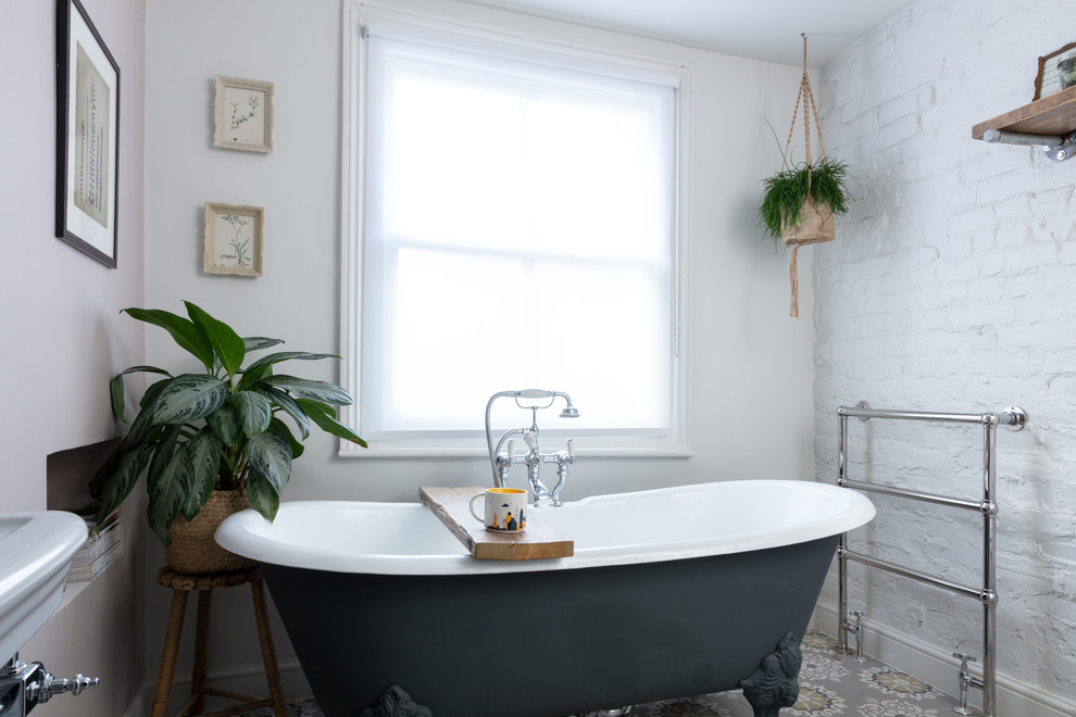 Diseño de cuarto de baño contemporáneo pequeño con bañera con patas, paredes blancas y suelo multicolor