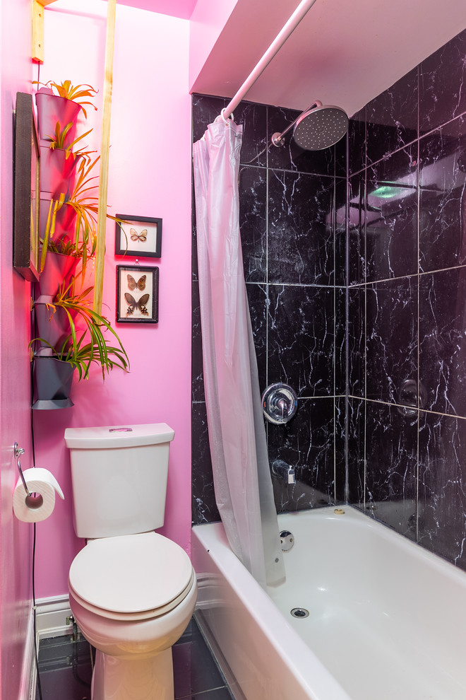 Cette image montre une petite salle de bain principale bohème en bois clair avec un placard à porte vitrée, une baignoire en alcôve, un combiné douche/baignoire, WC séparés, un carrelage noir, des carreaux de béton, un mur rose, un sol en carrelage de céramique, un plan vasque, un sol noir, une cabine de douche avec un rideau et un plan de toilette blanc.