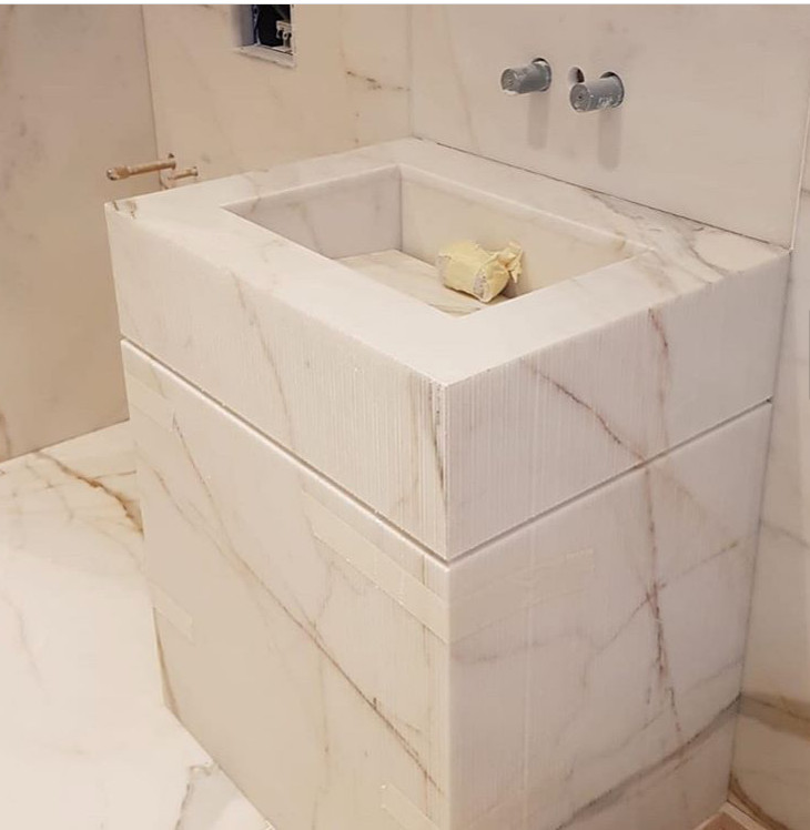 Immagine di una stanza da bagno per bambini minimalista con ante bianche, piastrelle di marmo, pavimento in marmo, lavabo da incasso, top in marmo e top bianco