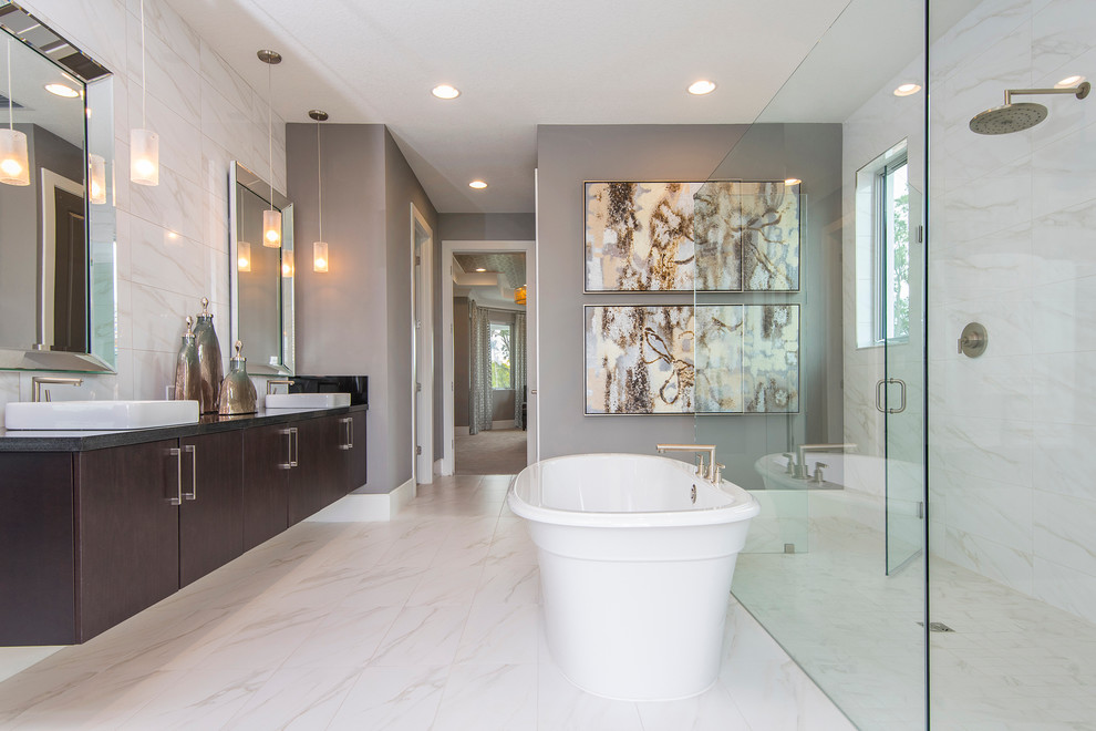 Cette photo montre une salle de bain principale chic en bois foncé avec un placard à porte plane, une baignoire indépendante, une douche à l'italienne, un mur gris, un lavabo suspendu et une cabine de douche à porte battante.